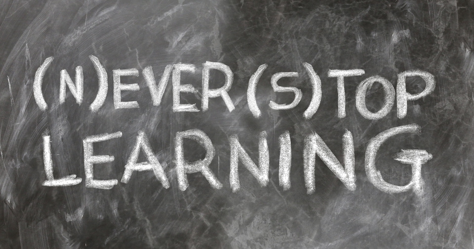 the words never stop learning is written in chalk on a blackboard