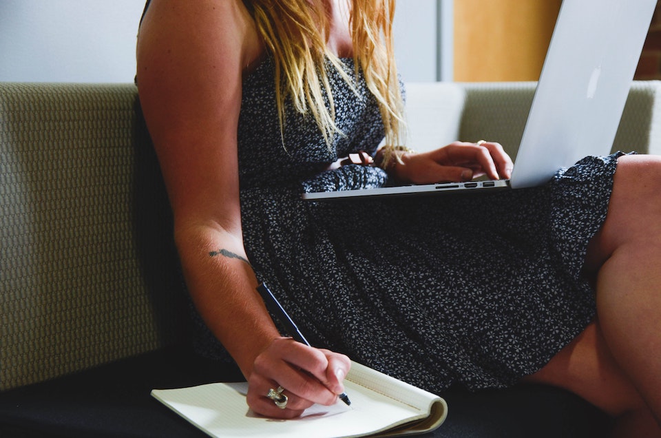 woman taking notes from her laptop